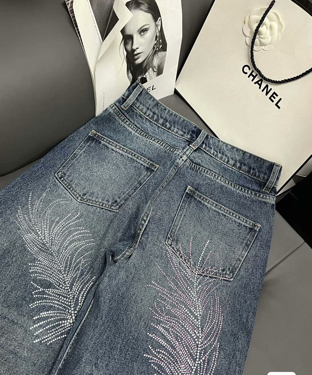 2026 Feather & Rhinestone Jeans: Featuring a high-waisted, wide-leg silhouette crafted from blue denim, with a unique feather and rhinestone embellishment design.