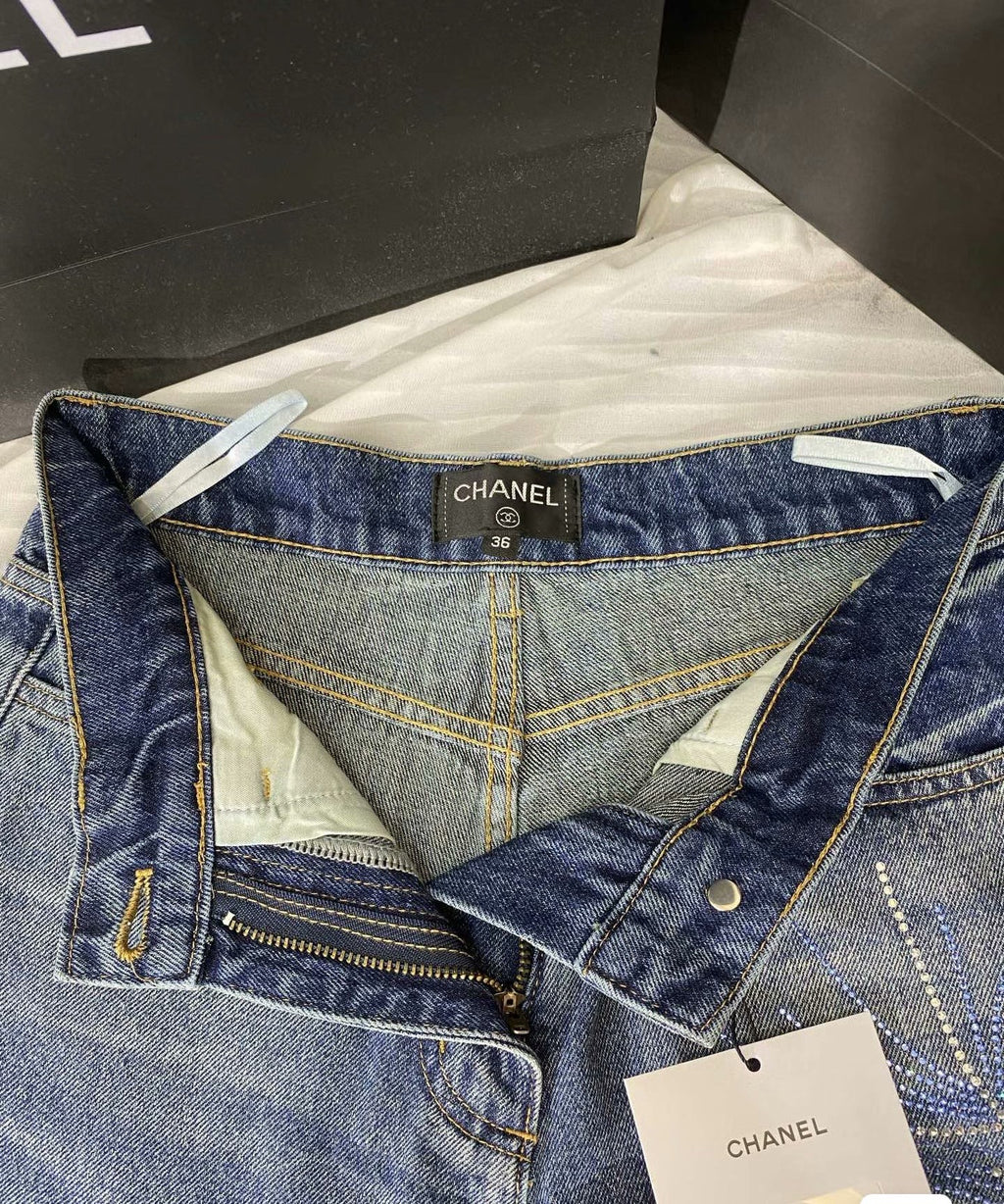 2026 Feather & Rhinestone Jeans: Featuring a high-waisted, wide-leg silhouette crafted from blue denim, with a unique feather and rhinestone embellishment design.