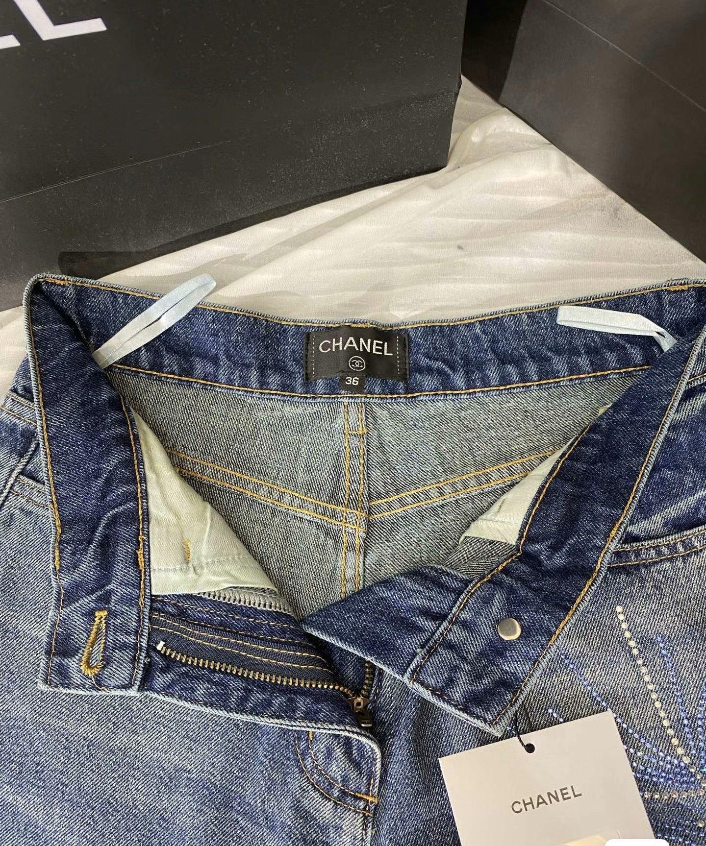 2026 Feather & Rhinestone Jeans: Featuring a high-waisted, wide-leg silhouette crafted from blue denim, with a unique feather and rhinestone embellishment design.