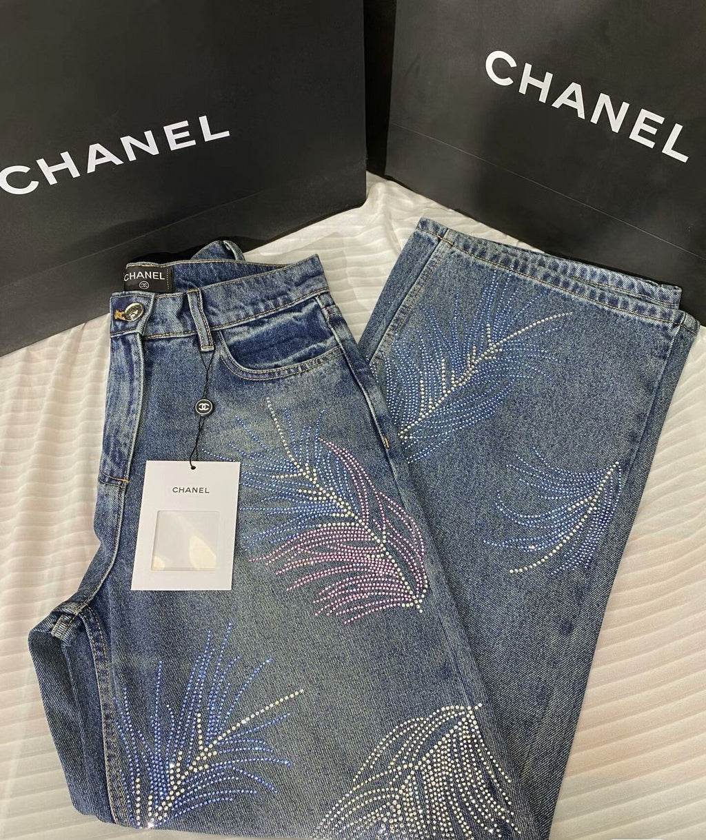 2026 Feather & Rhinestone Jeans: Featuring a high-waisted, wide-leg silhouette crafted from blue denim, with a unique feather and rhinestone embellishment design.