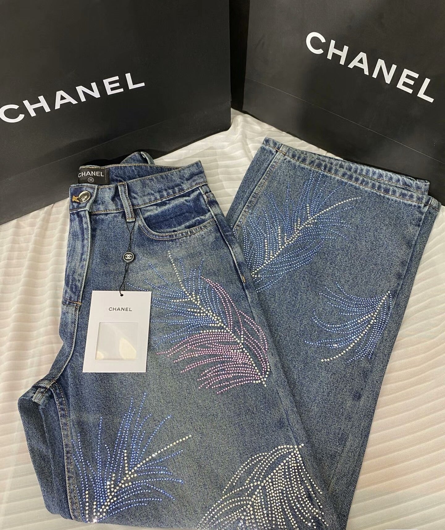 2026 Feather & Rhinestone Jeans: Featuring a high-waisted, wide-leg silhouette crafted from blue denim, with a unique feather and rhinestone embellishment design.