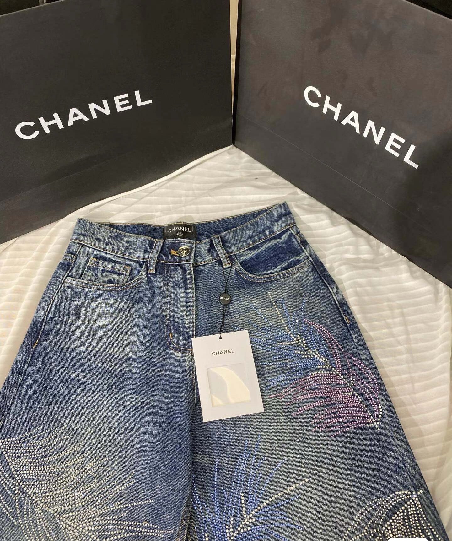 2026 Feather & Rhinestone Jeans: Featuring a high-waisted, wide-leg silhouette crafted from blue denim, with a unique feather and rhinestone embellishment design.